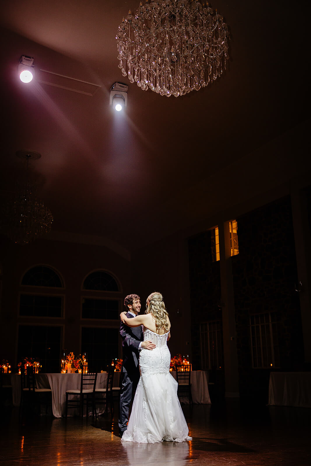 Poplar Springs Manor Spring Wedding Photography 53 bride and groom sharing a private dance in a ballroom with a large chandelier
