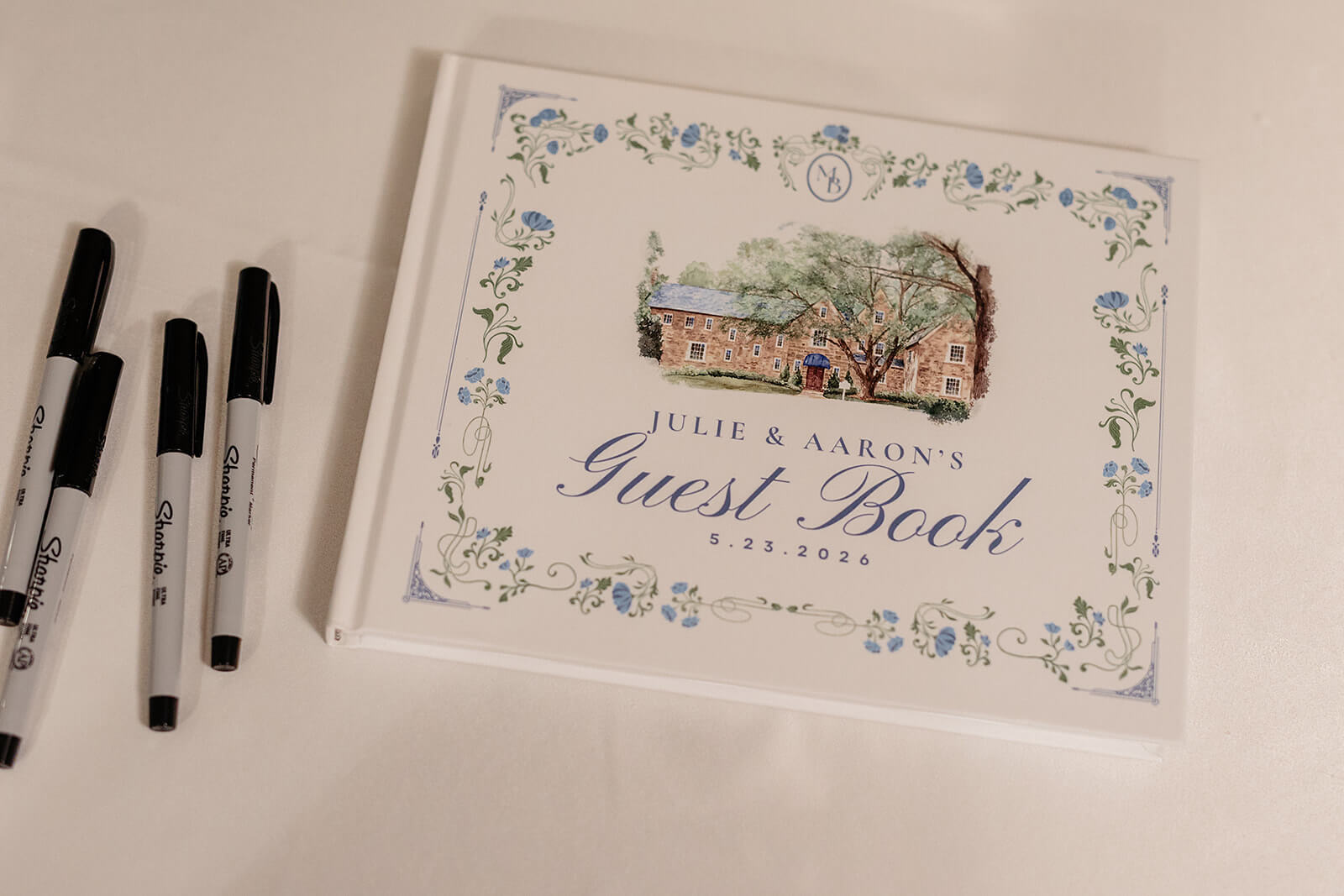 Poplar Springs Manor Spring Wedding Photography 9 detail photo of couple's guest book decorated with picture of venue and surrounded by blue florals