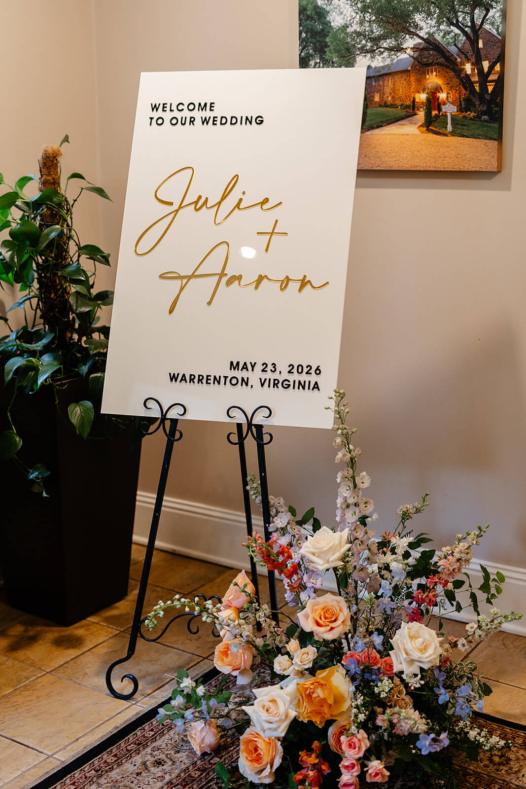 Poplar Springs Manor Spring Wedding Photography 13 detail photo of wedding sign with gold lettering and large floral arrangement on the floor next to it