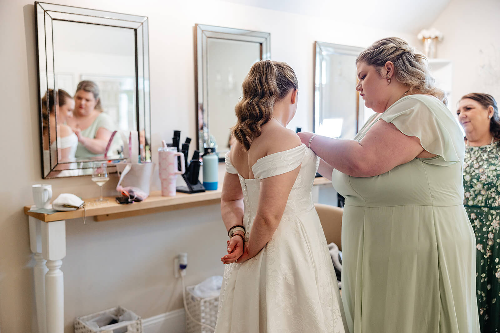 The Mill at Fine Creek Spring Wedding Photography in Powhatan 8 bride in wedding dress being helped by bridesmaid