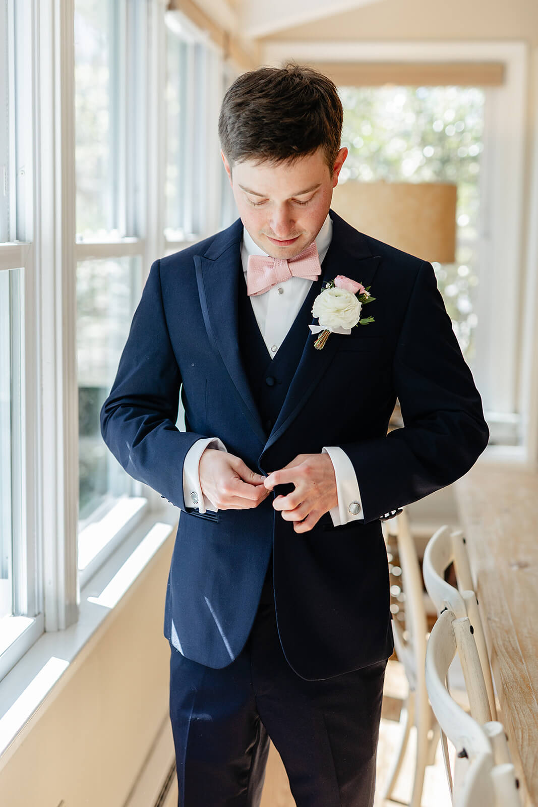 The Mill at Fine Creek Spring Wedding Photography in Powhatan 9 groom in sunlit window buttoning his suit