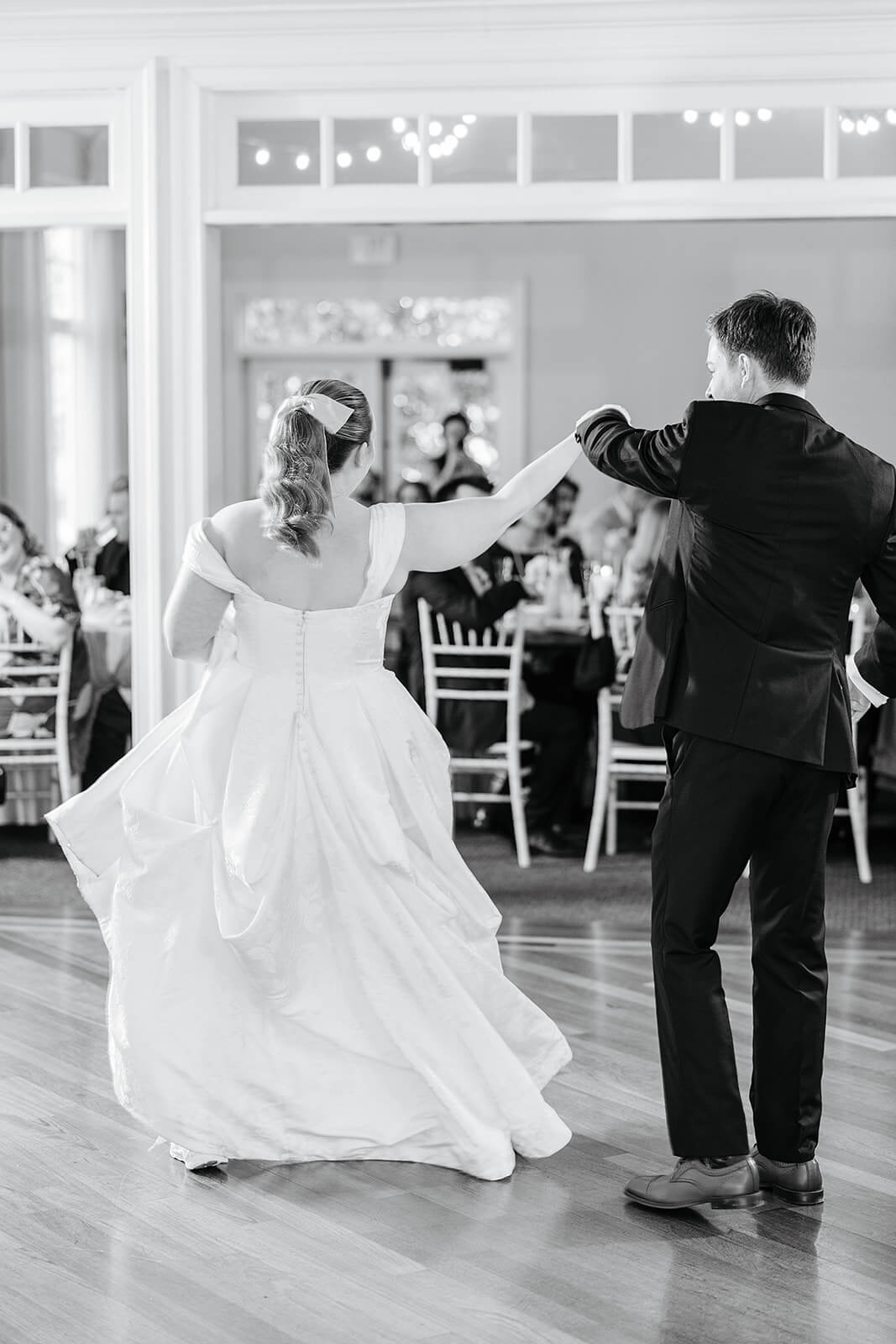 The Mill at Fine Creek Spring Wedding Photography in Powhatan 36 black and white photo of groom twirling bride in front of all the guests