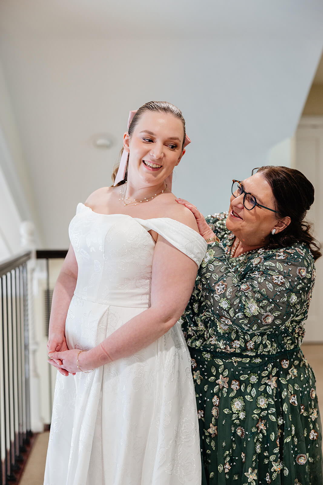 The Mill at Fine Creek Spring Wedding Photography in Powhatan 12 bride smiling over her shoulder at her mom in green floral dress