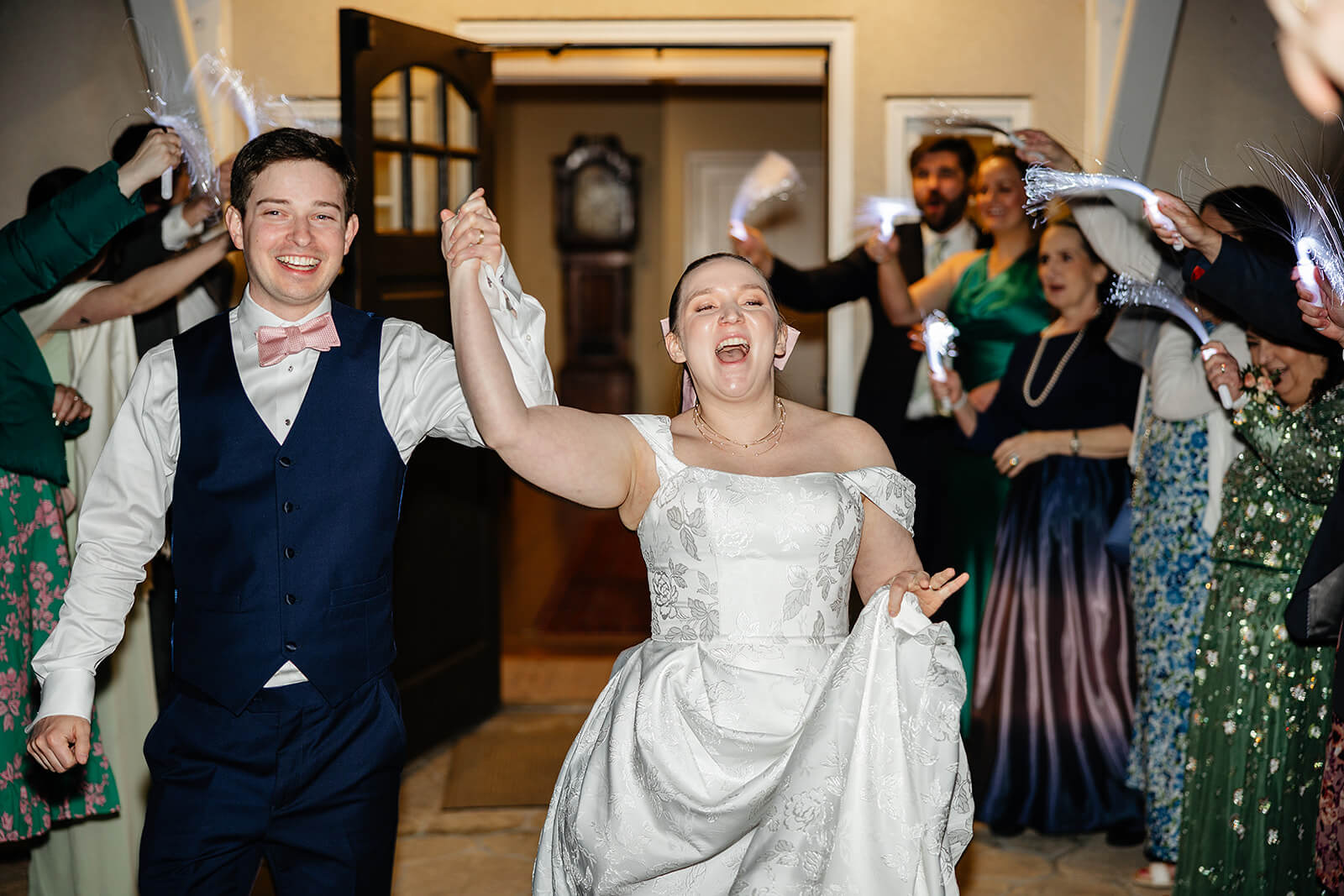 The Mill at Fine Creek Spring Wedding Photography in Powhatan 47 bride and groom holding hands and exiting the venue with their guests around them