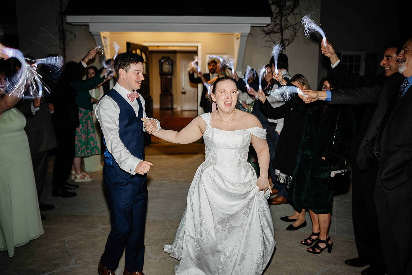 The Mill at Fine Creek Spring Wedding Photography in Powhatan 48 bride and groom holding hands and exiting the venue with their guests around them