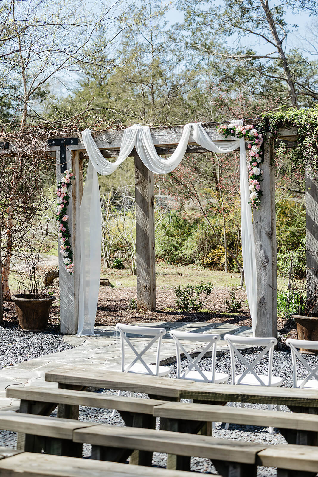 The Mill at Fine Creek Spring Wedding Photography in Powhatan 18 detail photo of wooden alter draped in white and covered in pink and white flowers