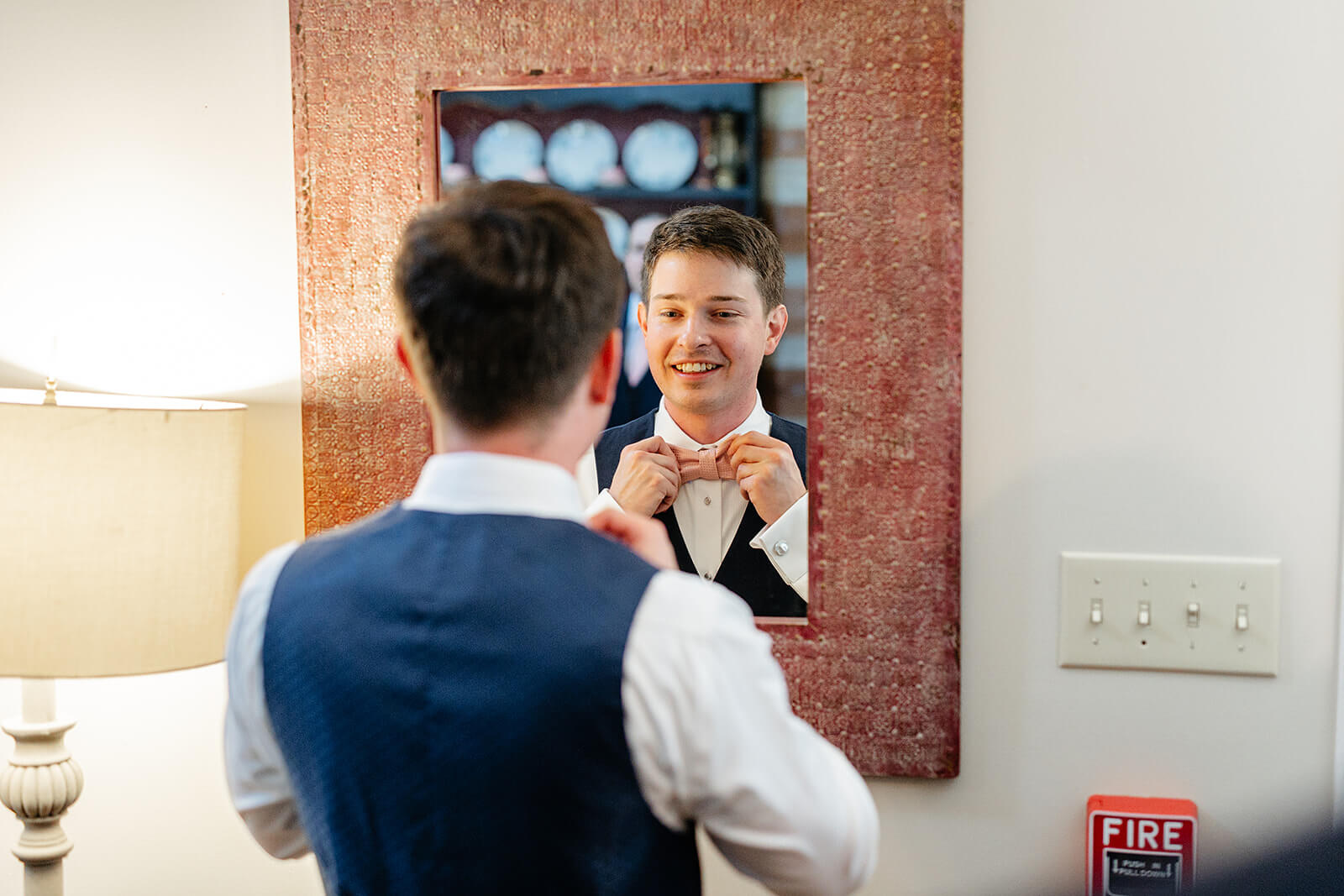The Mill at Fine Creek Spring Wedding Photography in Powhatan 4 groom straightening his bowtie in the mirror