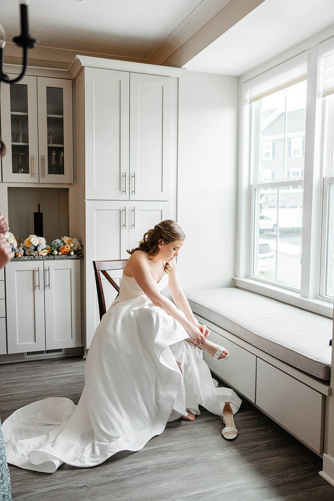 Allegheny RiverTrail Park Spring Wedding Photography 3 bride in her dress sitting by a window putting on her wedding heels