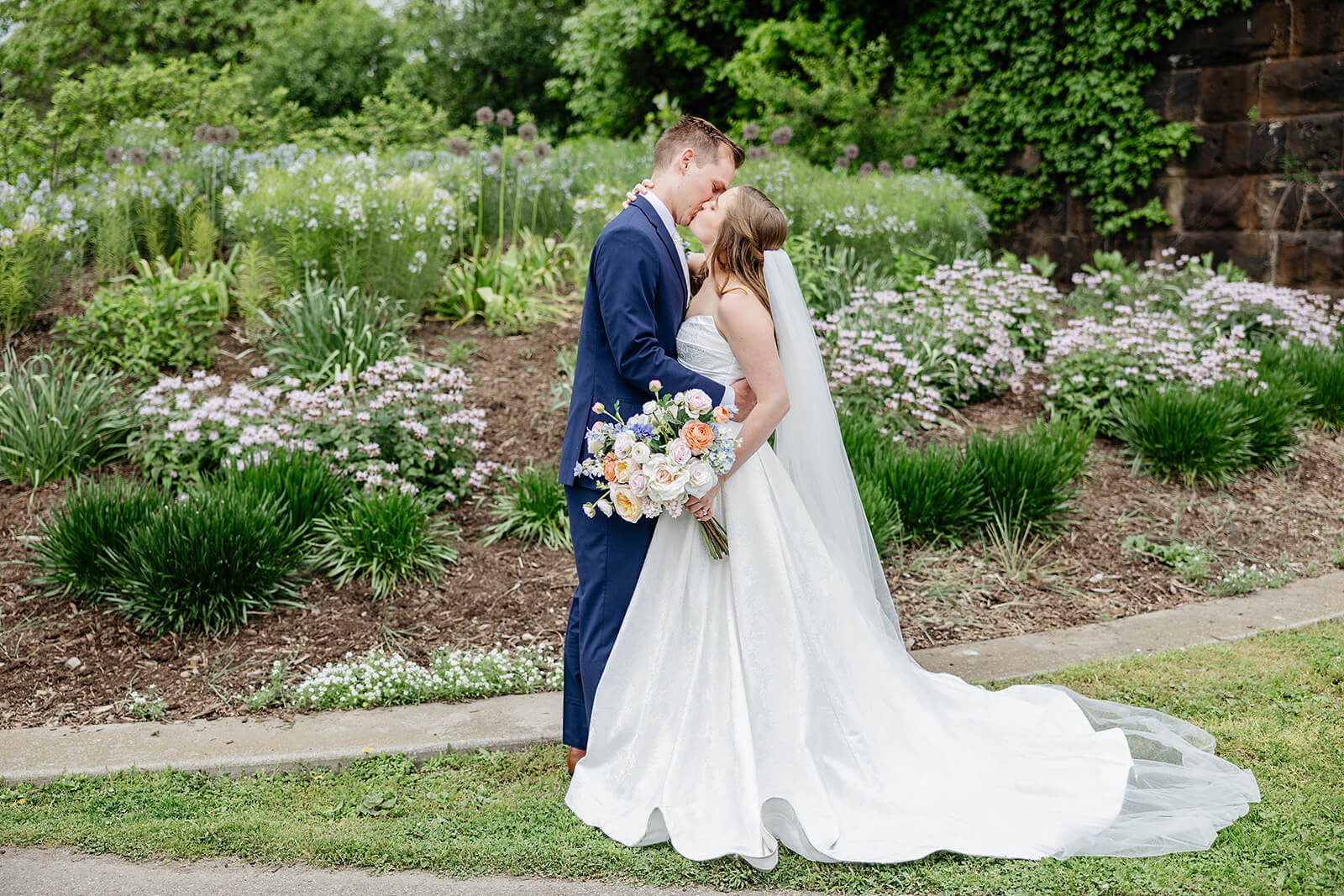 Allegheny RiverTrail Park Spring Wedding Photography 25 bride and groom kissing in front of a large garden bed
