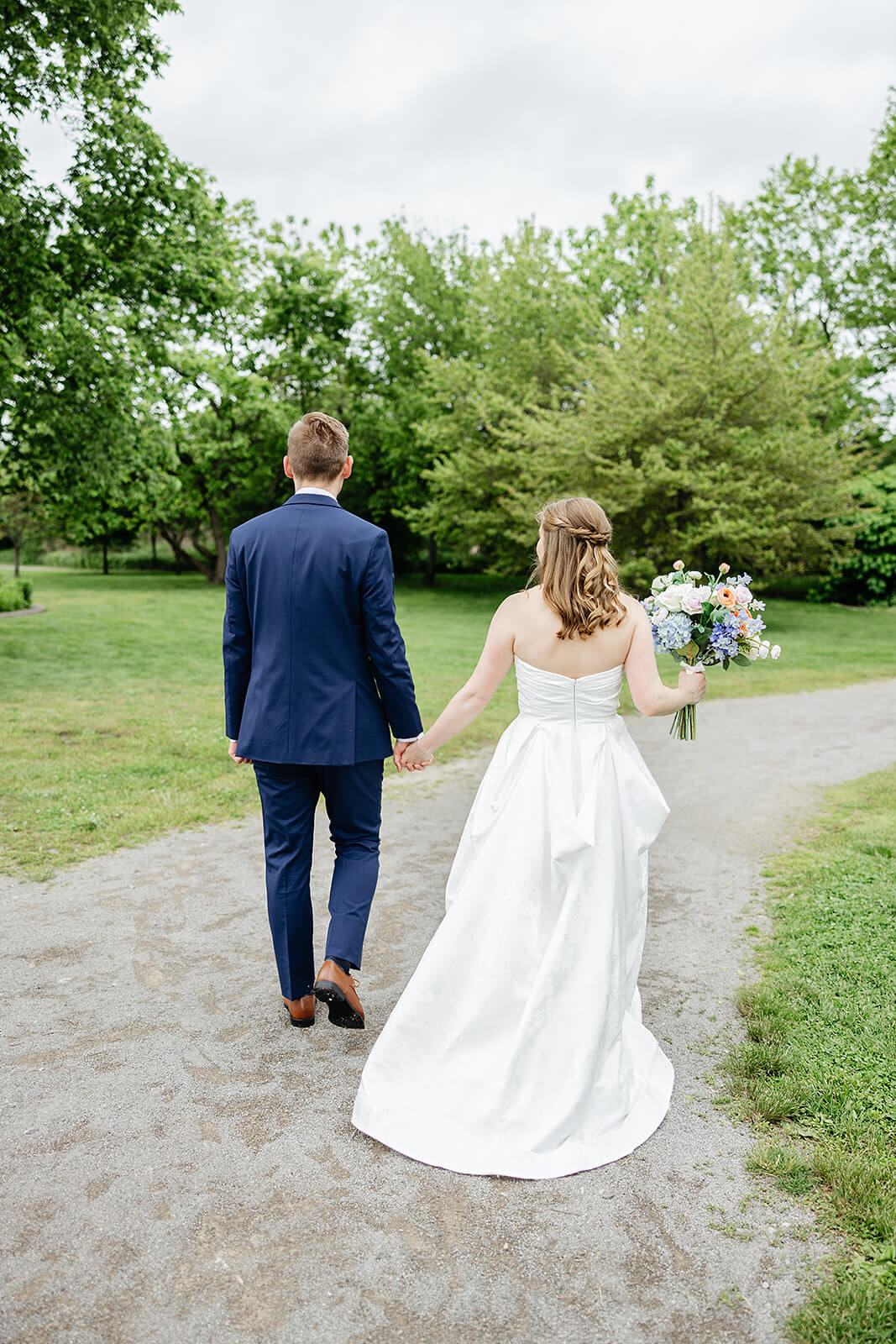 Allegheny RiverTrail Park Spring Wedding Photography 26 bride and groom holding hands and walking down a gravel path