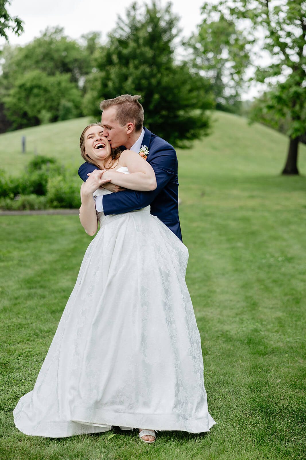 Allegheny RiverTrail Park Spring Wedding Photography 28 groom hugging and kissing bride on the cheek as she laughs