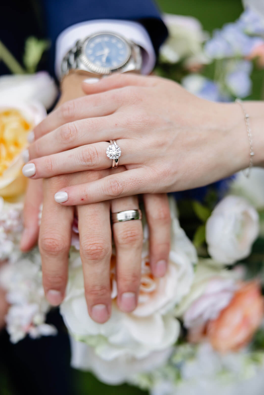 Allegheny RiverTrail Park Spring Wedding Photography 29 detail photo of bride and groom's hands with their wedding rings propped on top of the brides bouquet