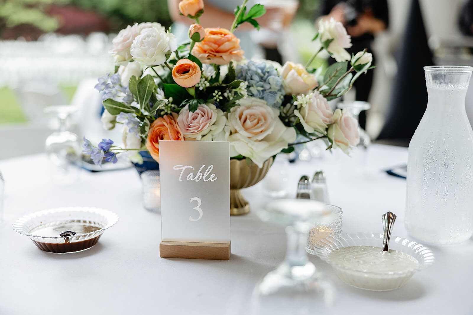 Allegheny RiverTrail Park Spring Wedding Photography 30 detail photo of reception table with table number and floral arrangement with blue, white, and orange flowers