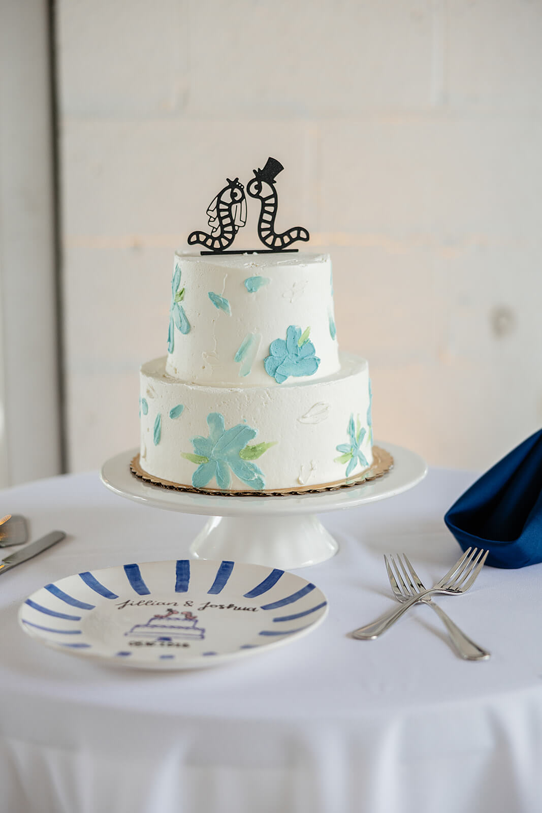 Allegheny RiverTrail Park Spring Wedding Photography 31 wedding cake with blue flowers and bride and groom worm cake topper