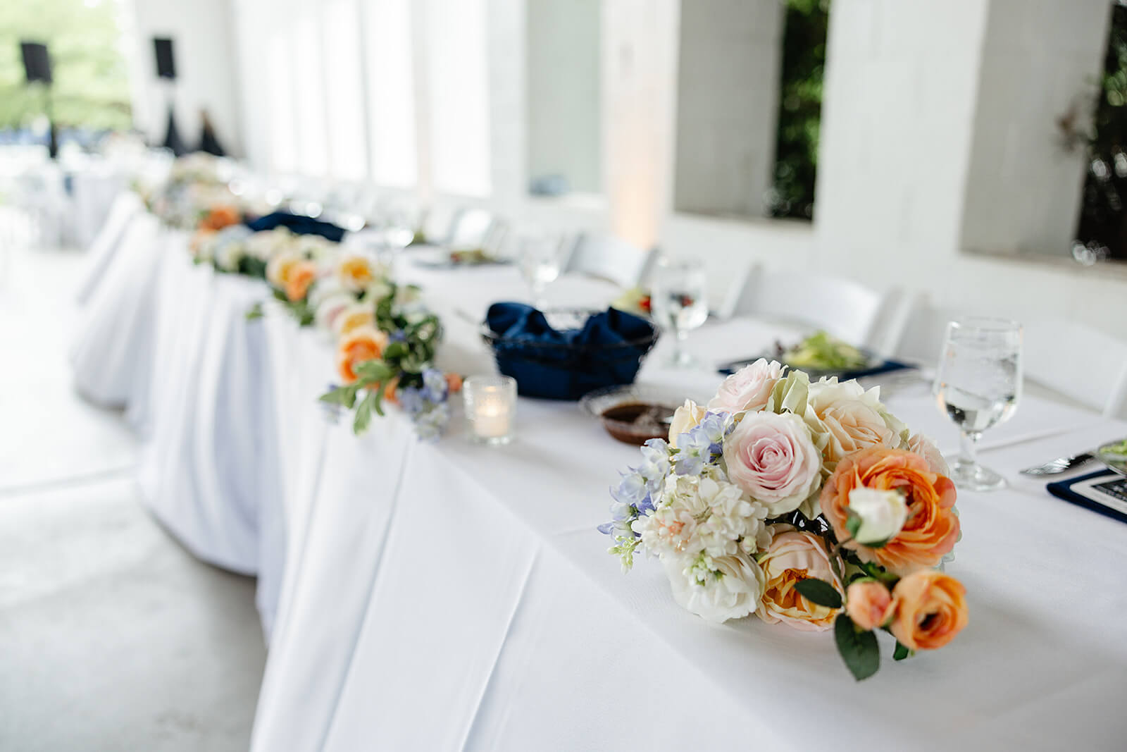 Allegheny RiverTrail Park Spring Wedding Photography 32 detail photo of long reception table with small candles and orange, blue and white floral arrangements