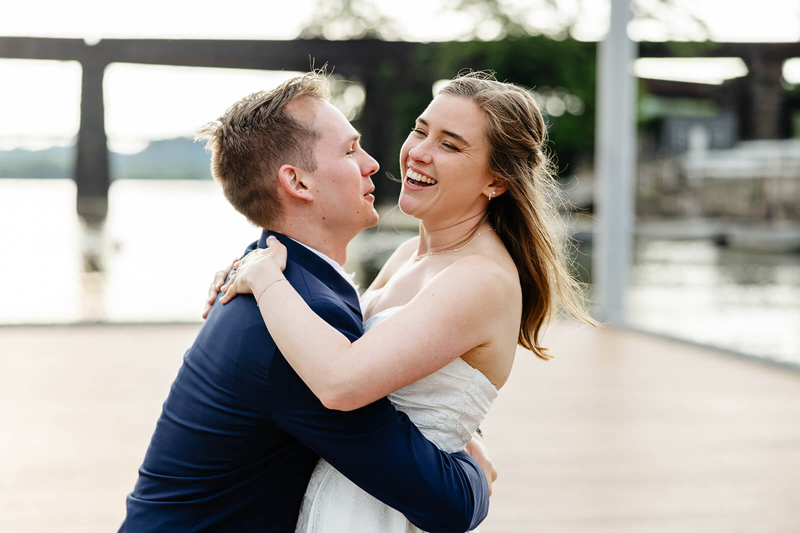 Allegheny RiverTrail Park Spring Wedding Photography 38 groom picking up smiling bride outside on riverside dock