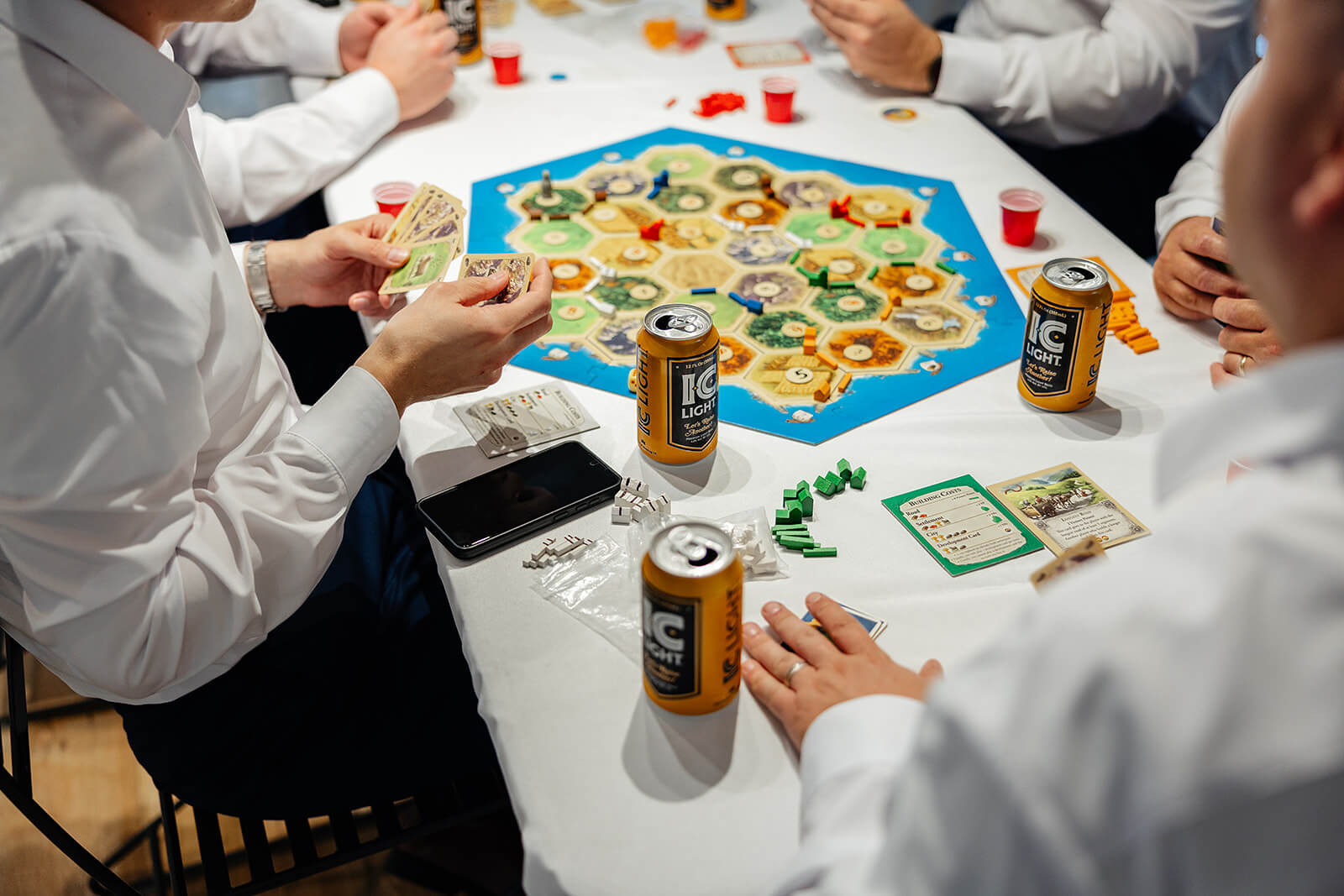 Allegheny RiverTrail Park Spring Wedding Photography 7 groom and groomsmen sitting at a table with a board game and cans of beer
