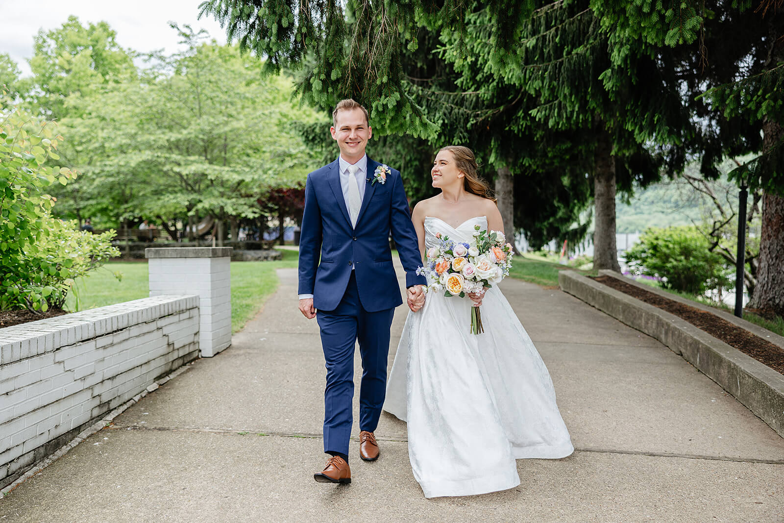 Allegheny RiverTrail Park Spring Wedding Photography 10 bride and groom holding hands and walking down large sidewalk