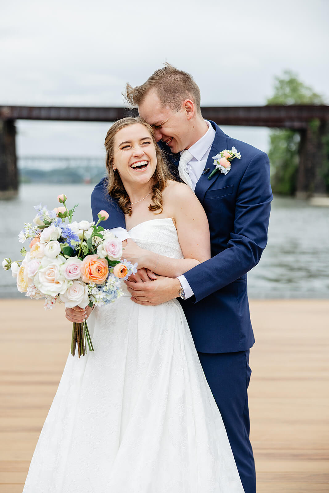 Allegheny RiverTrail Park Spring Wedding Photography 12 groom snuggling his bride on a dock by a river
