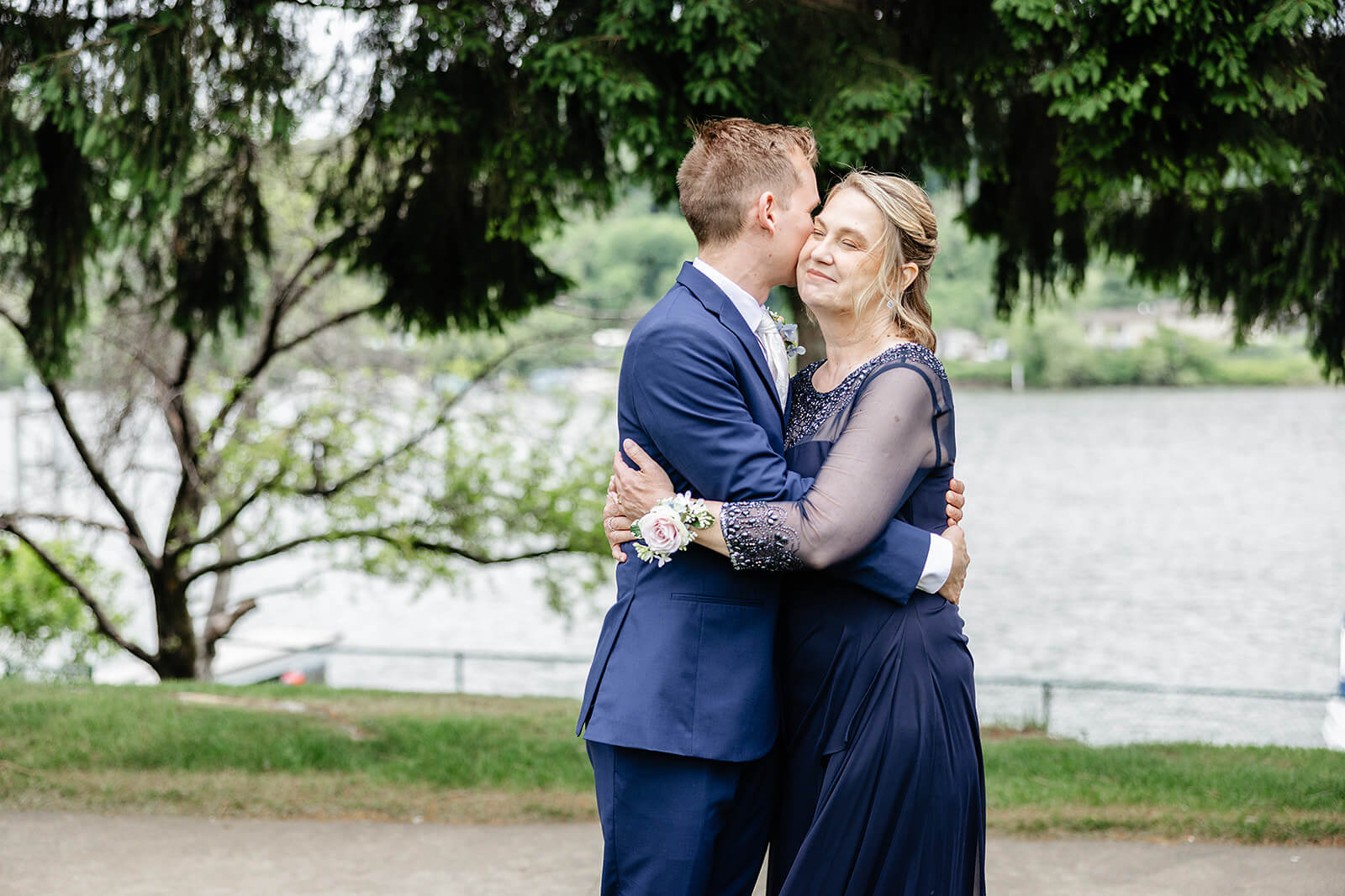Allegheny RiverTrail Park Spring Wedding Photography 13 groom hugging his mother outside with a river in the background
