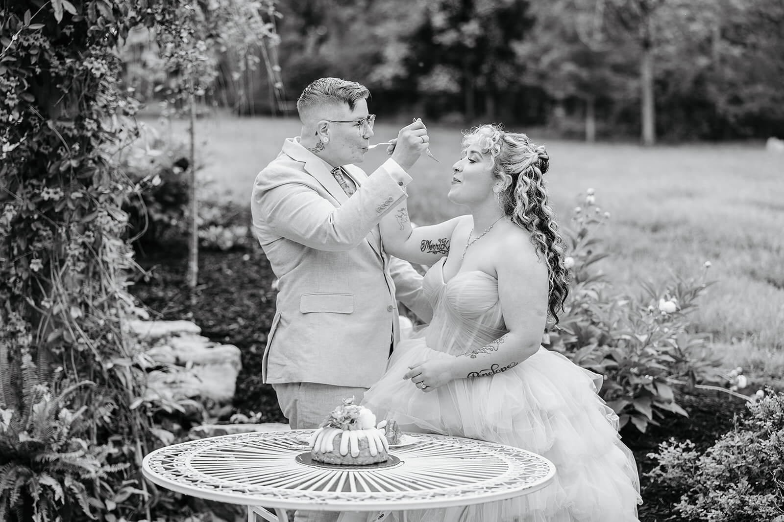 Vaughan Greenhouse Spring Wedding Photography 32 black and white photo of bride and groom feeding each other the cake