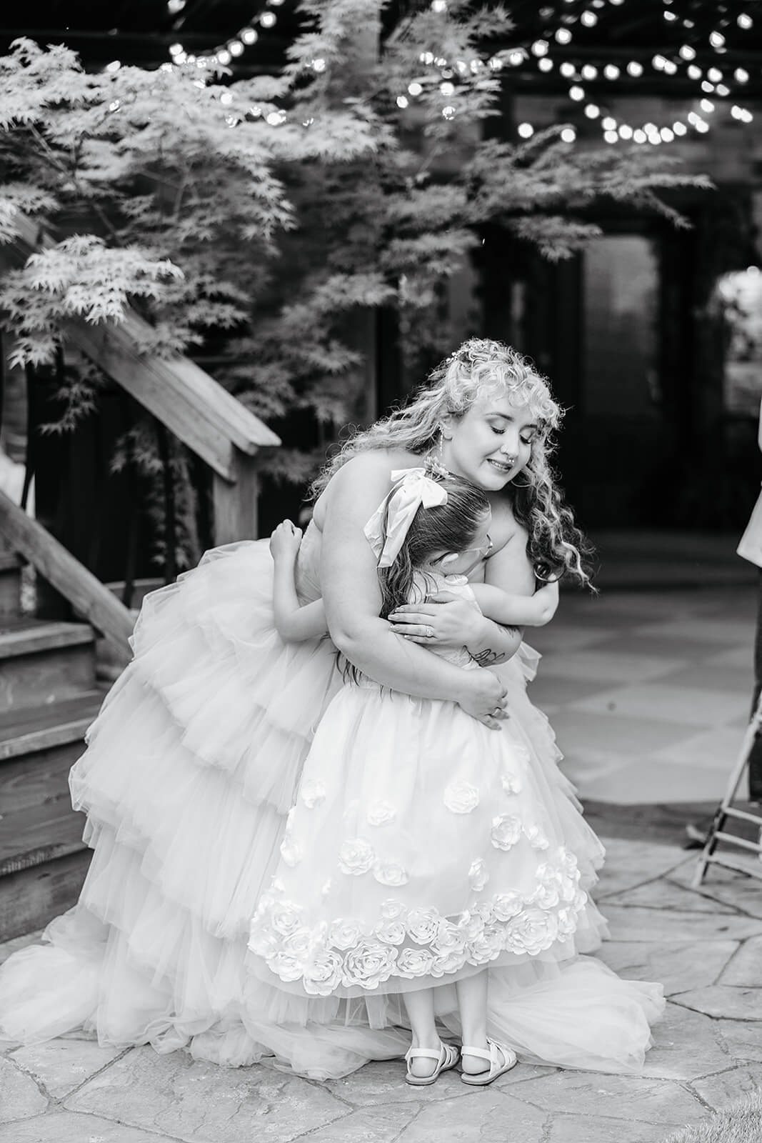 Vaughan Greenhouse Spring Wedding Photography 35 black and white photo of bride hugging flower girl
