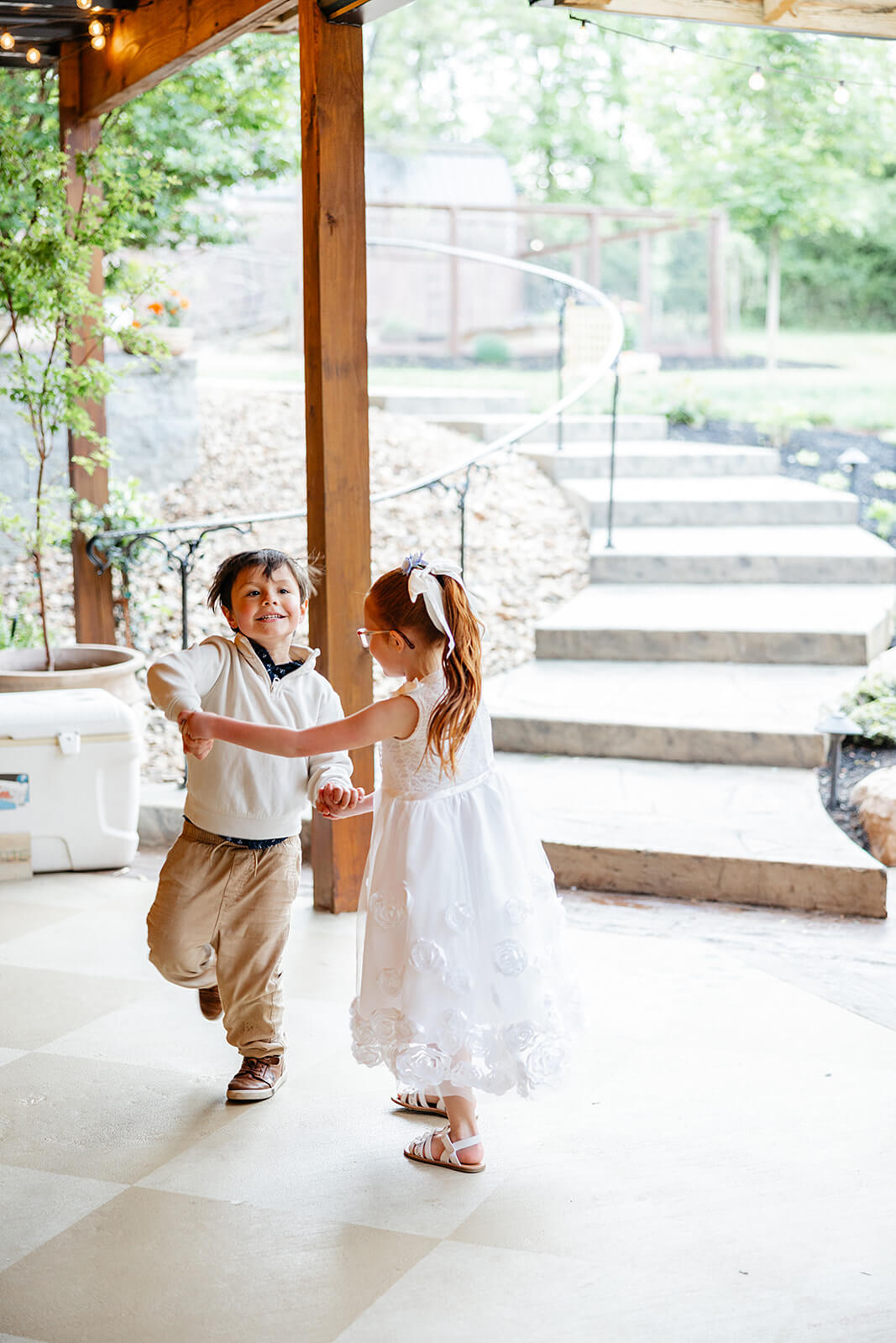 Vaughan Greenhouse Spring Wedding Photography 36 flower girl and little boy holding hands and dancing together