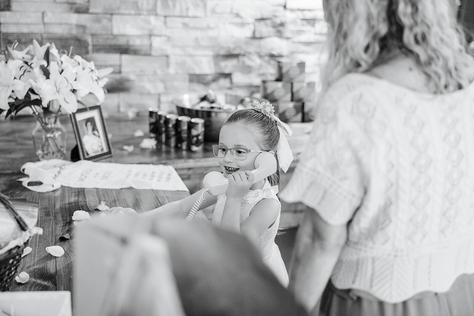 Vaughan Greenhouse Spring Wedding Photography 37 black and white photo of flower girl leaving a message on the rotary phone
