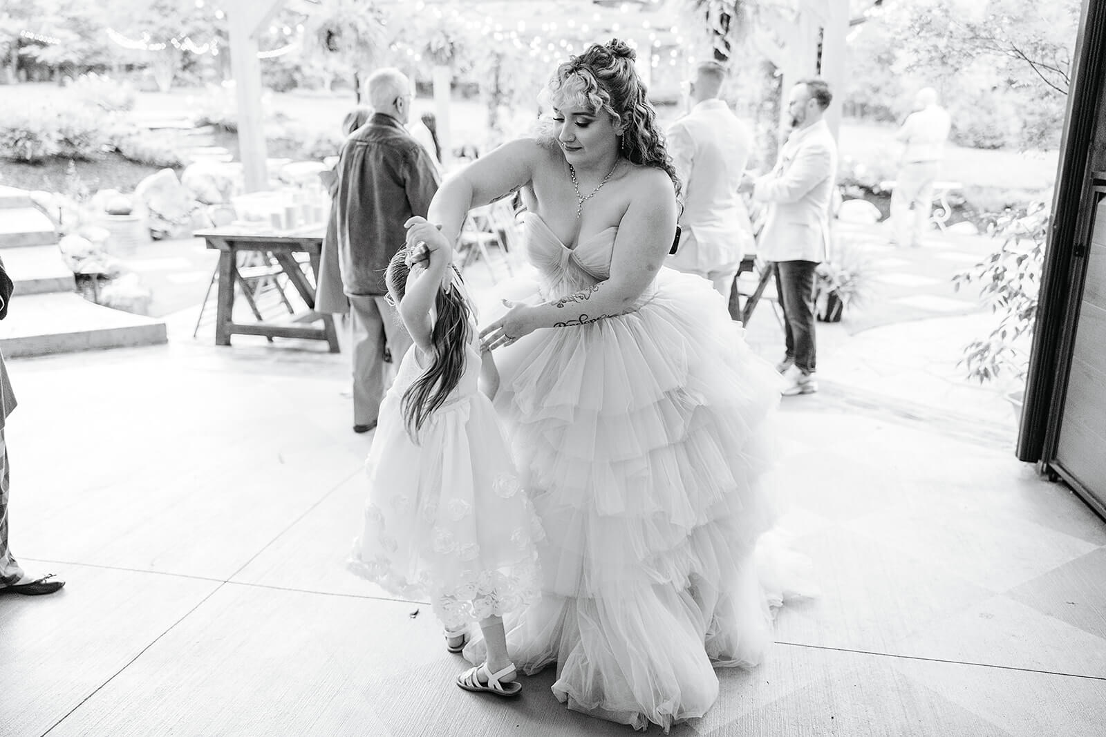 Vaughan Greenhouse Spring Wedding Photography 38 black and white photo of bride dancing with flower girl
