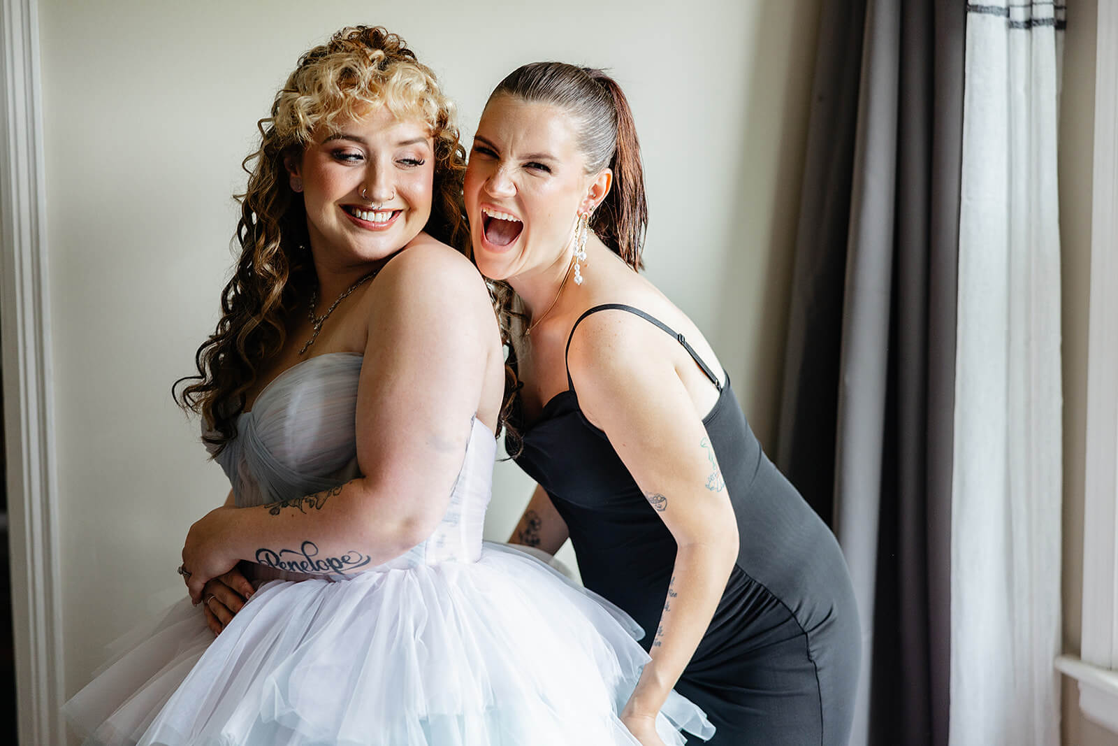 Vaughan Greenhouse Spring Wedding Photography 2 friend helping bride get into her dress