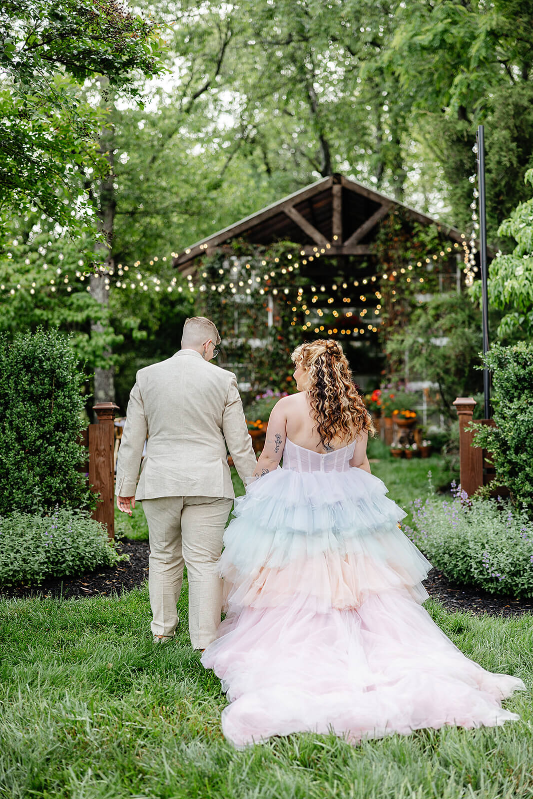 Vaughan Greenhouse Spring Wedding Photography 13 bride and groom holding hands and walking across the lawn toward the greenhouse