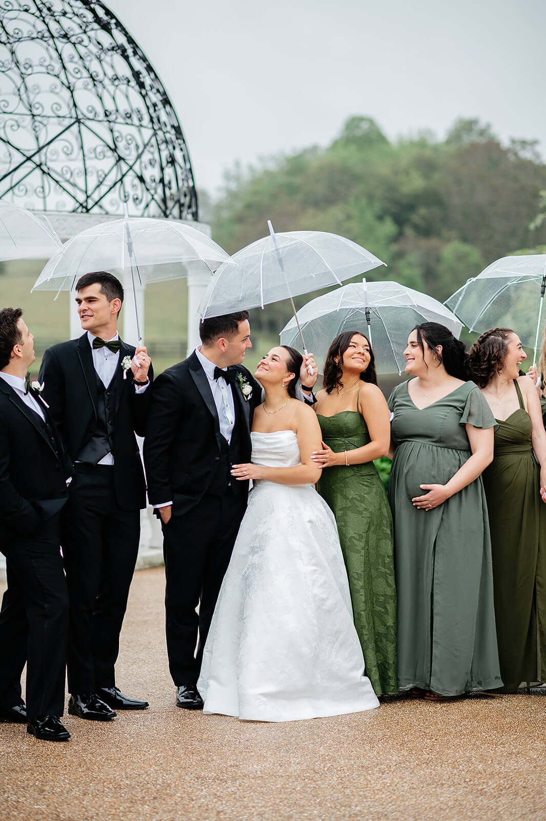 Matt + Adriana's May Wedding Photography 15 bride and groom surrounded by their wedding party holding umbrellas outside