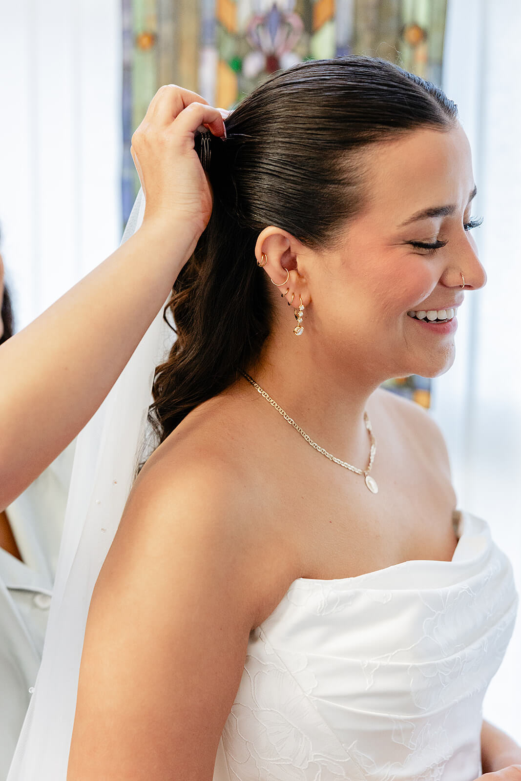 Matt + Adriana's May Wedding Photography 2 bride smiling in her wedding dress while getting her veil pinned into her hair