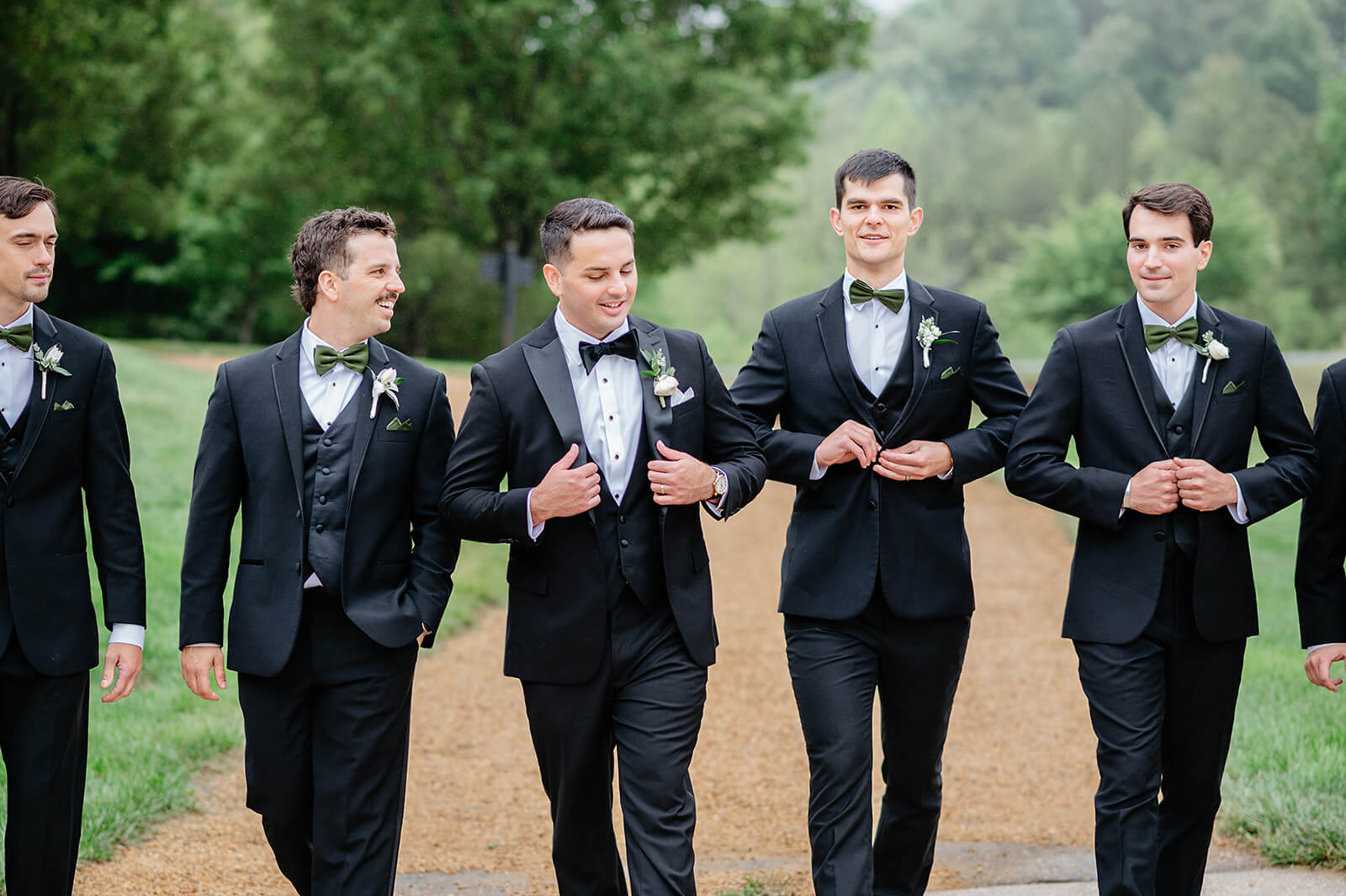 Matt + Adriana's May Wedding Photography 18 groom and his groomsmen in tuxes walking down a gravel path in a line
