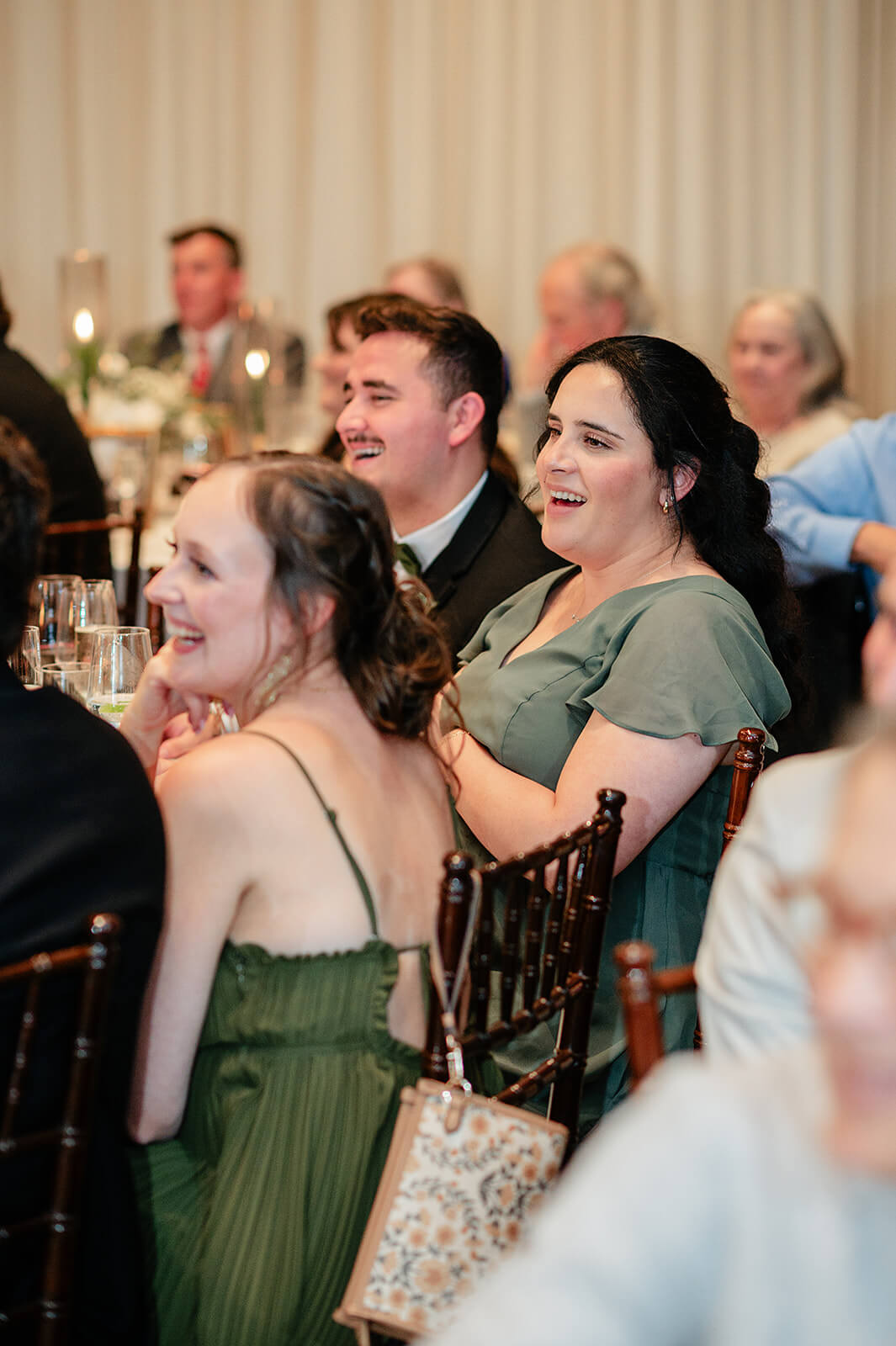 Matt + Adriana's May Wedding Photography 33 bridesmaid sitting at the reception laughing at a speech