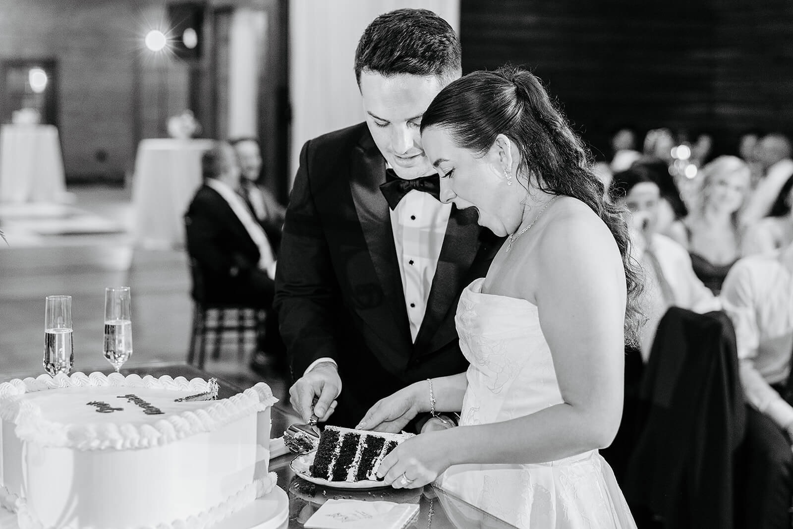 Matt + Adriana's May Wedding Photography 34 black and white photo of bride and groom cutting a slice of the wedding cake