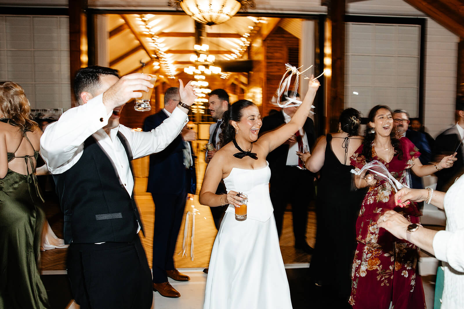 Matt + Adriana's May Wedding Photography 38 bride wearing a bowtie waving ribbons and cheering
