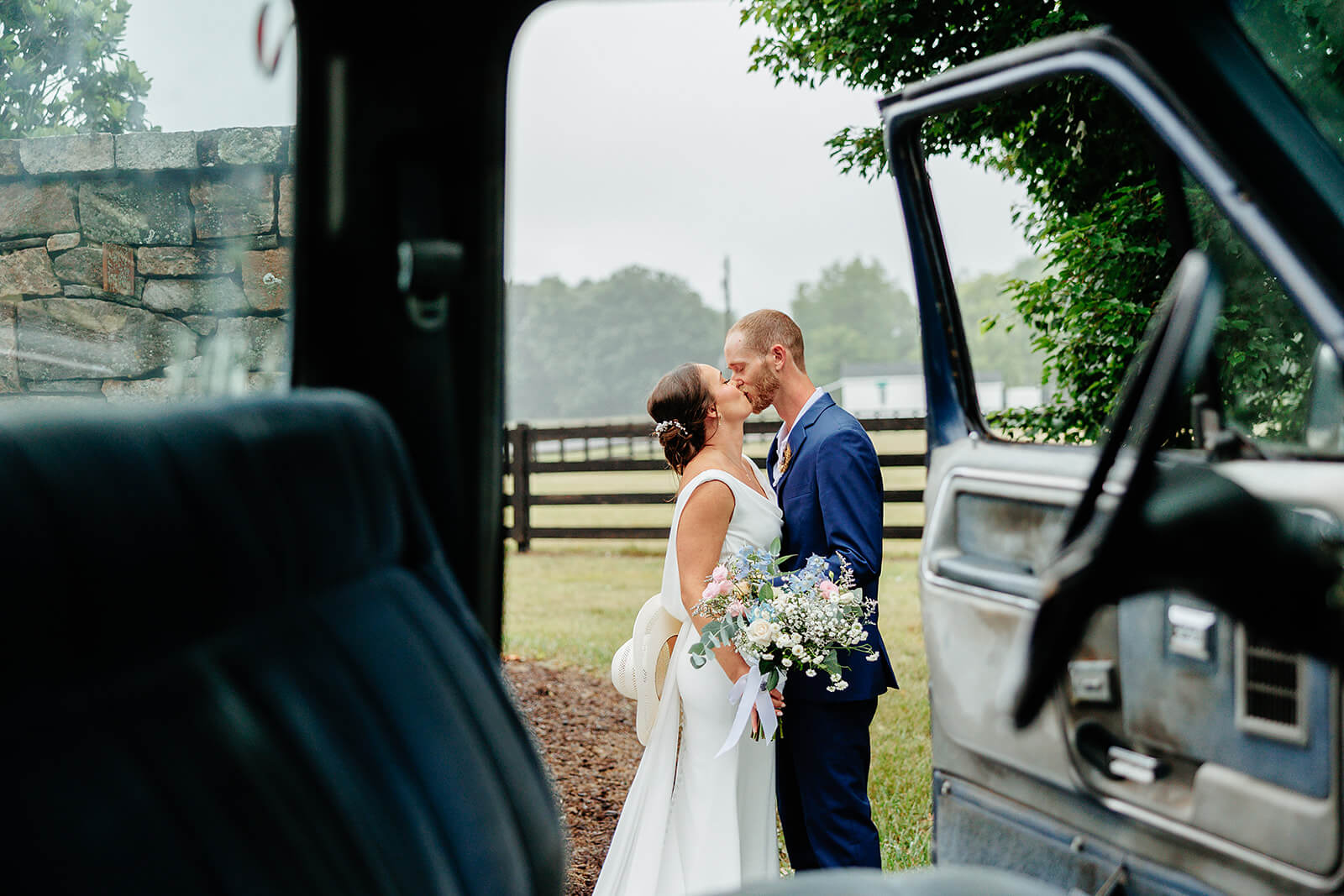Family Farm Spring Wedding Photography 33 couple kissing, camera is looking through truck cab into the open door