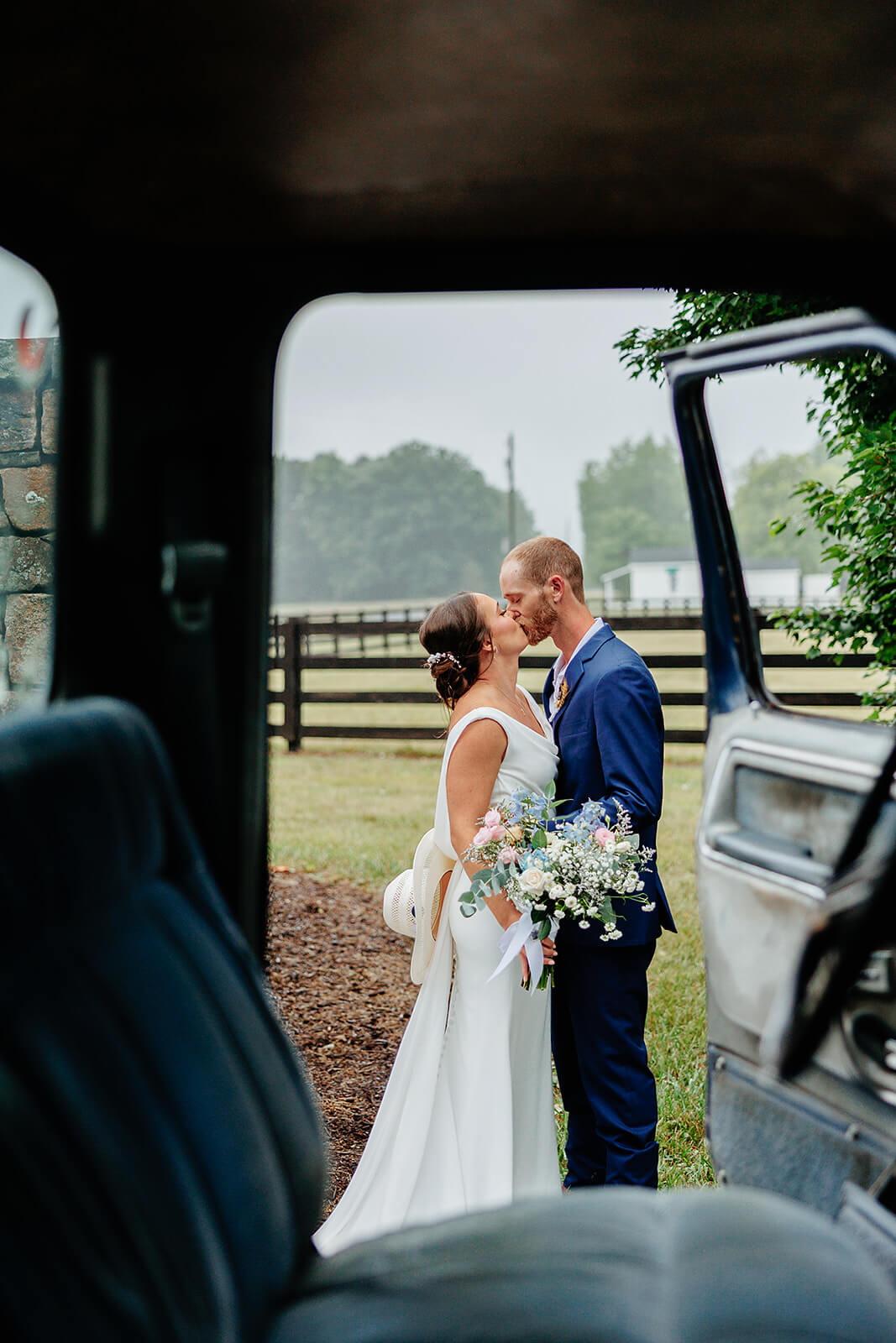 Family Farm Spring Wedding Photography 34 couple kissing, camera is looking through truck cab into the open door