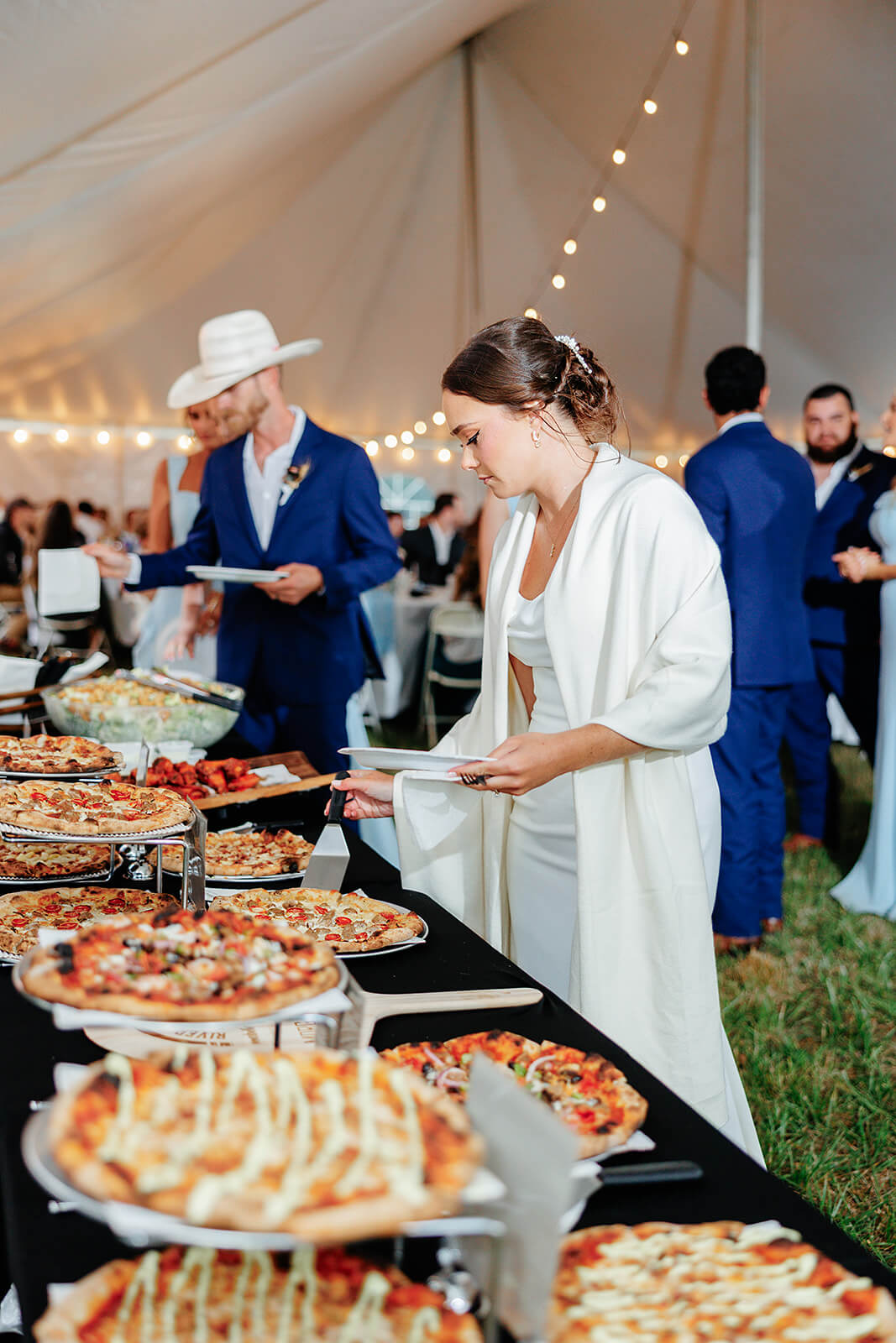 Family Farm Spring Wedding Photography 38 bride walking through pizza buffet catering in the reception tent