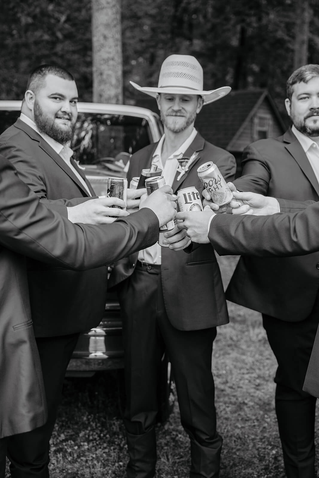 Family Farm Spring Wedding Photography 6 black and white photo of groom and groomsmen clinking beer cans together
