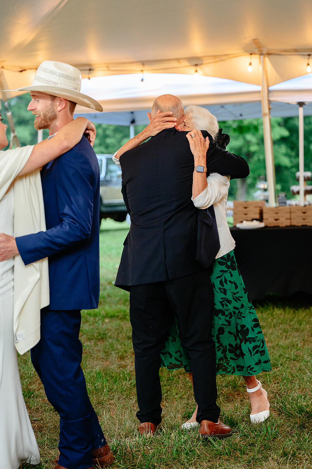 Family Farm Spring Wedding Photography 42 an older couple hugging and dancing next to bride and groom