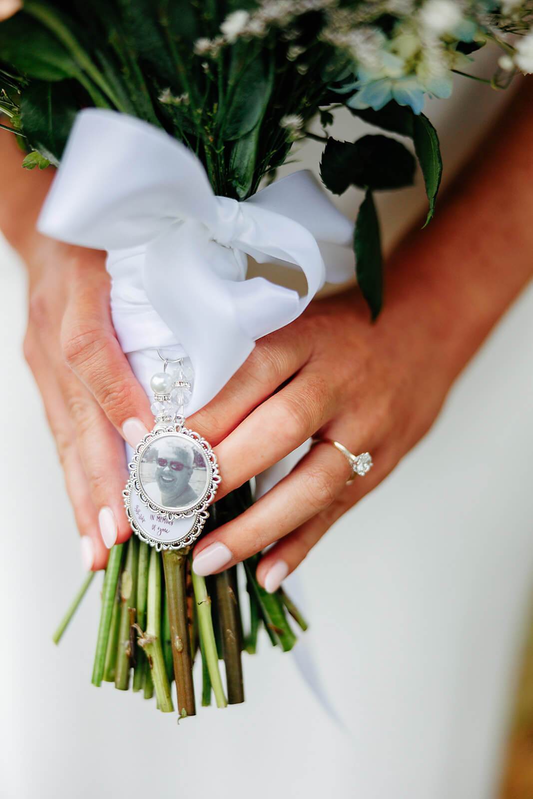 Family Farm Spring Wedding Photography 12 detail photo of bride bouquet with locket picture of a relative hanging from the bottom
