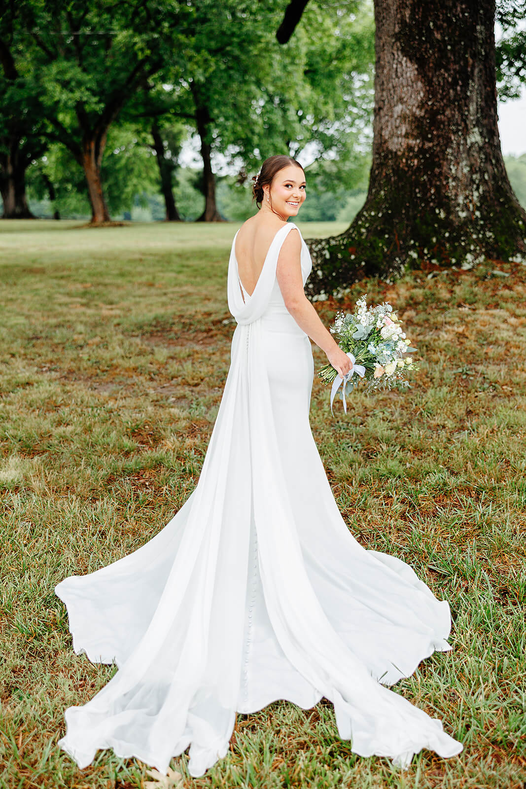 Family Farm Spring Wedding Photography 14 portrait of bride with her back facing the camera, she is holding her bouquet