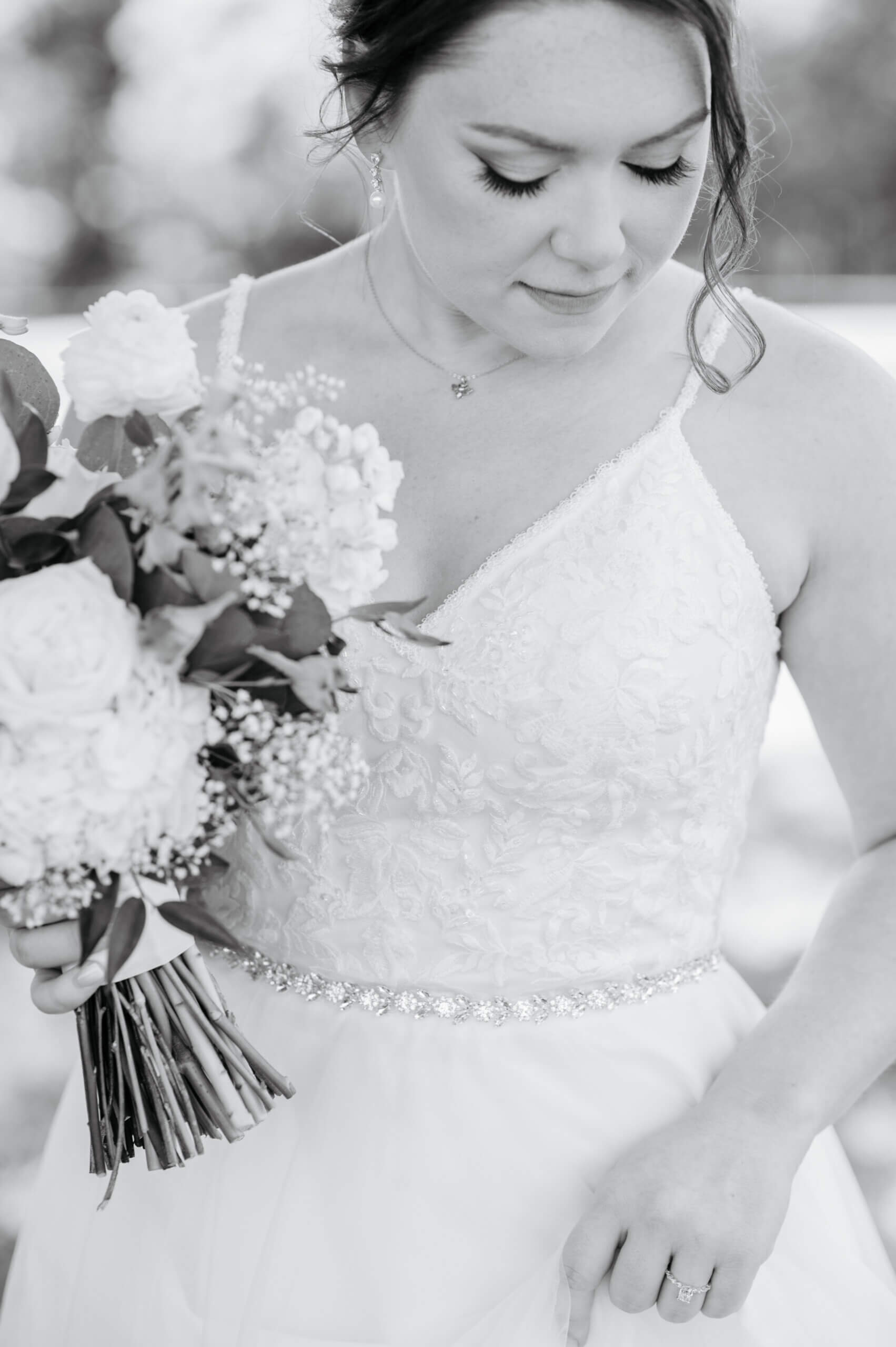 Malden Hill Spring Wedding Photography 16 black and white photo of bride looking down as she holds her bouquet and dress