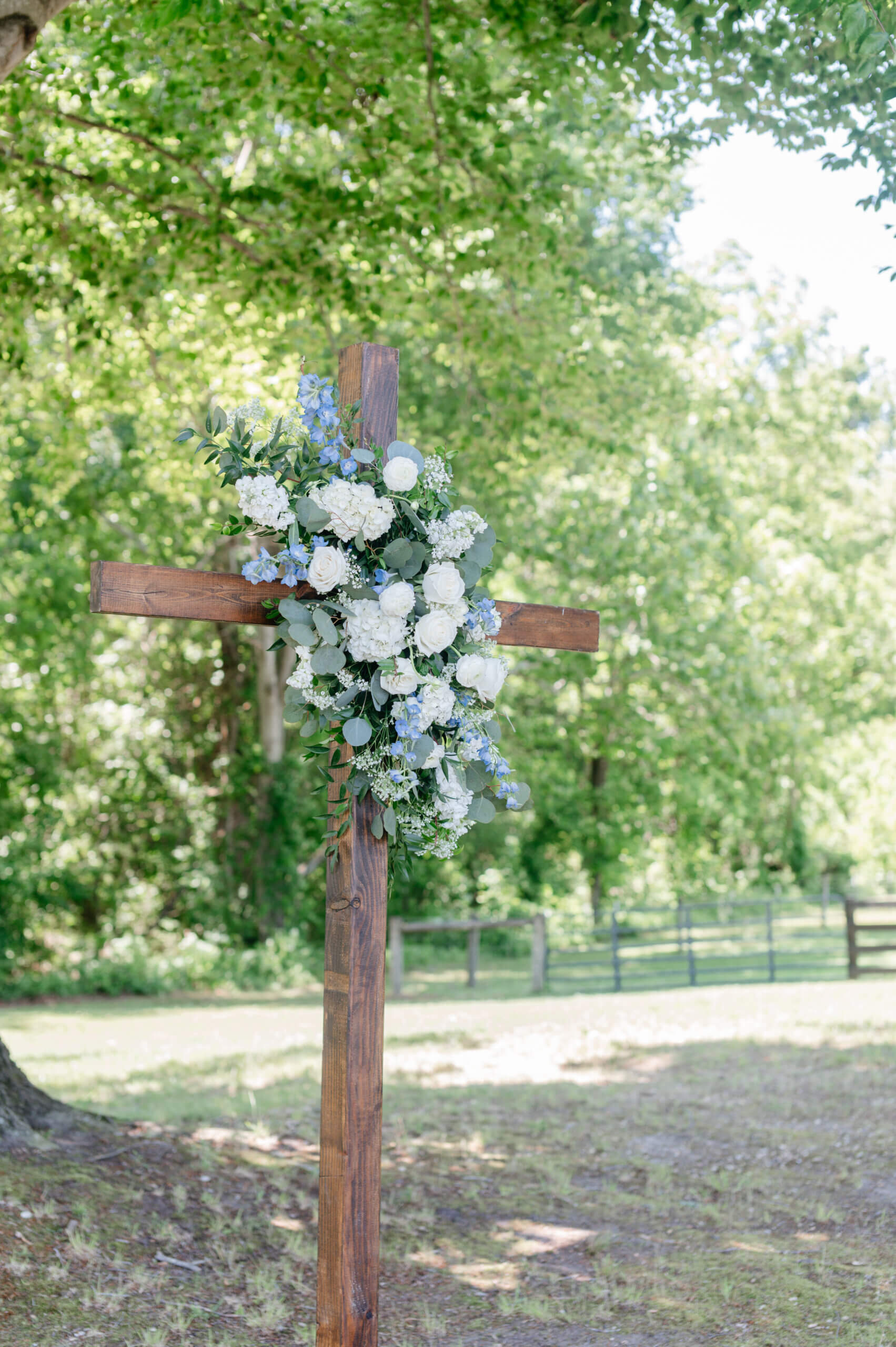 Malden Hill Spring Wedding Photography 4 wooden cross with blue and white florals and greenery covering it