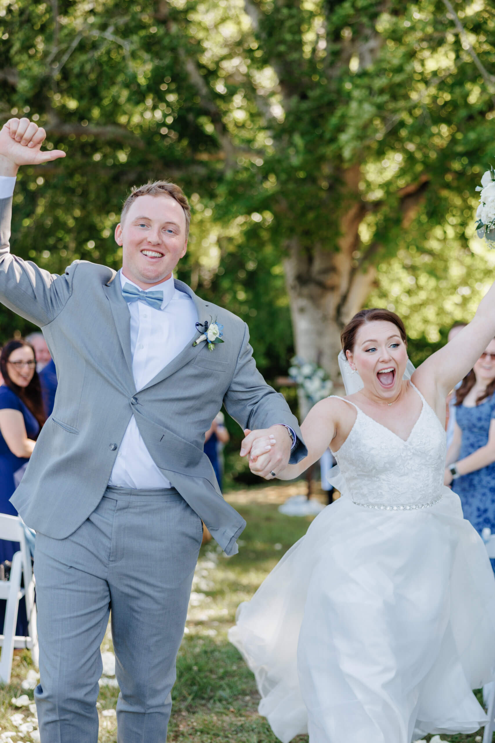 Malden Hill Spring Wedding Photography 18 bride and groom holding hands and running down the aisle cheering