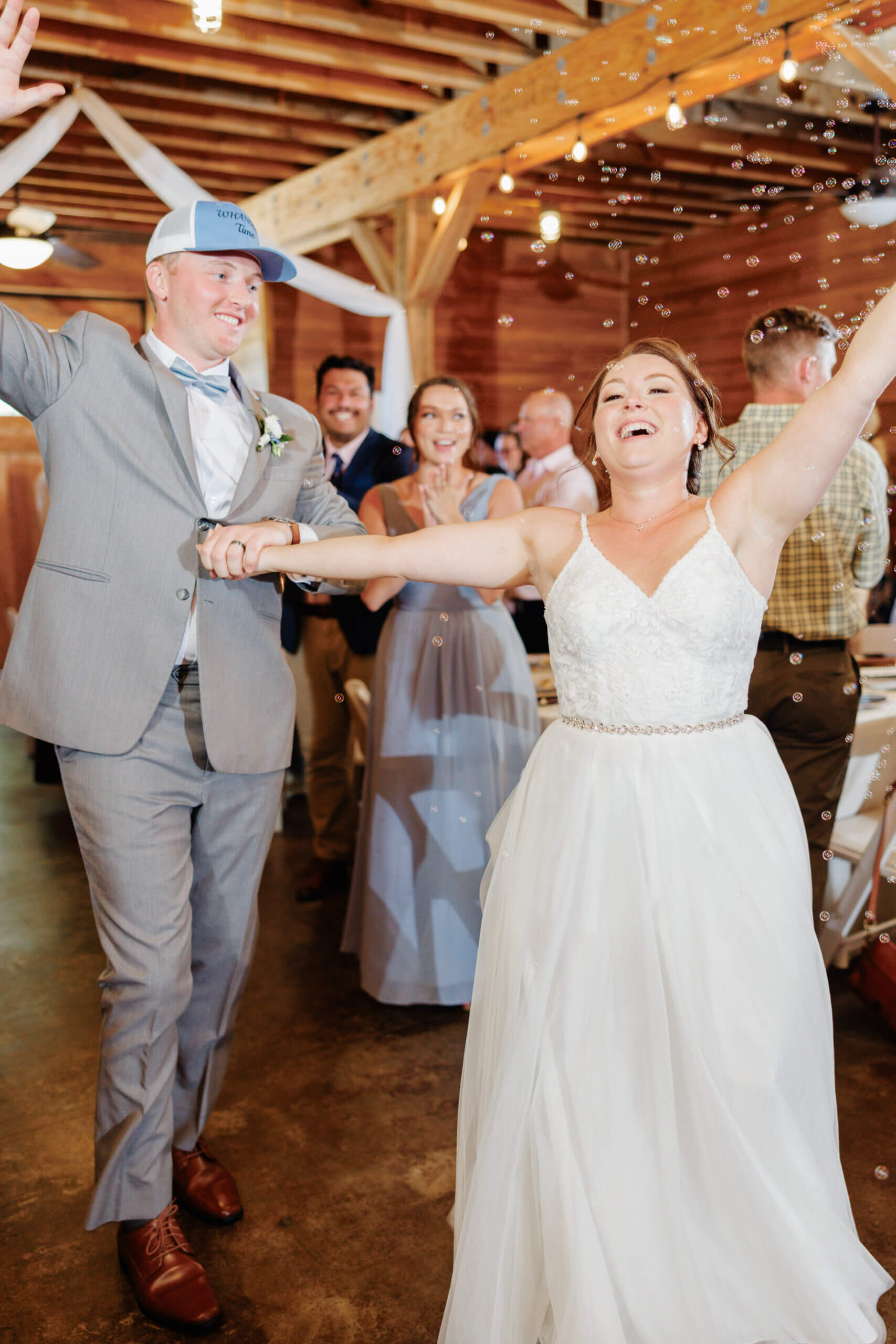 Malden Hill Spring Wedding Photography 22 bride and groom holding hands and dancing with bubbles floating in the background