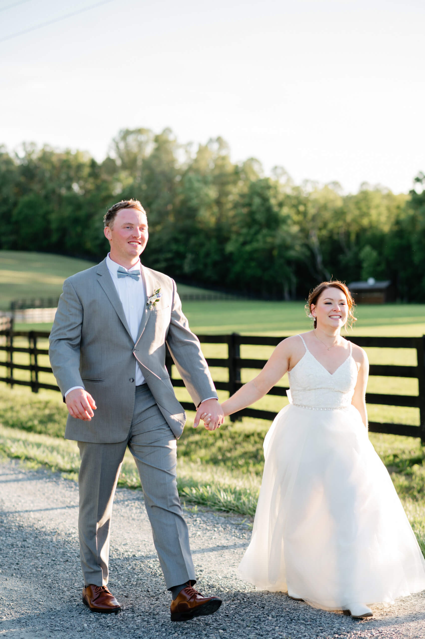 Malden Hill Spring Wedding Photography 35 bride and groom holding hands and walking down a gravel road together