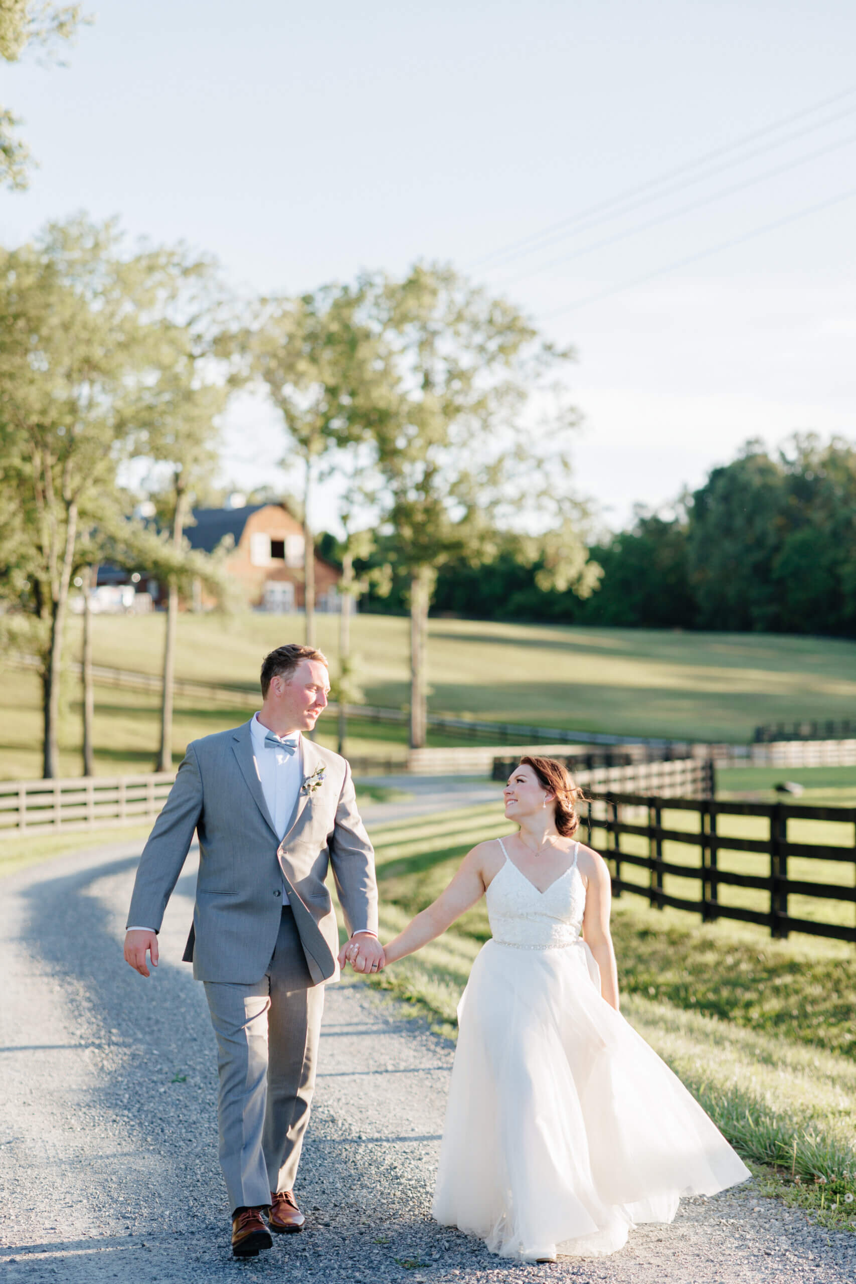 Malden Hill Spring Wedding Photography 36 bride and groom holding hands and walking down a gravel road together